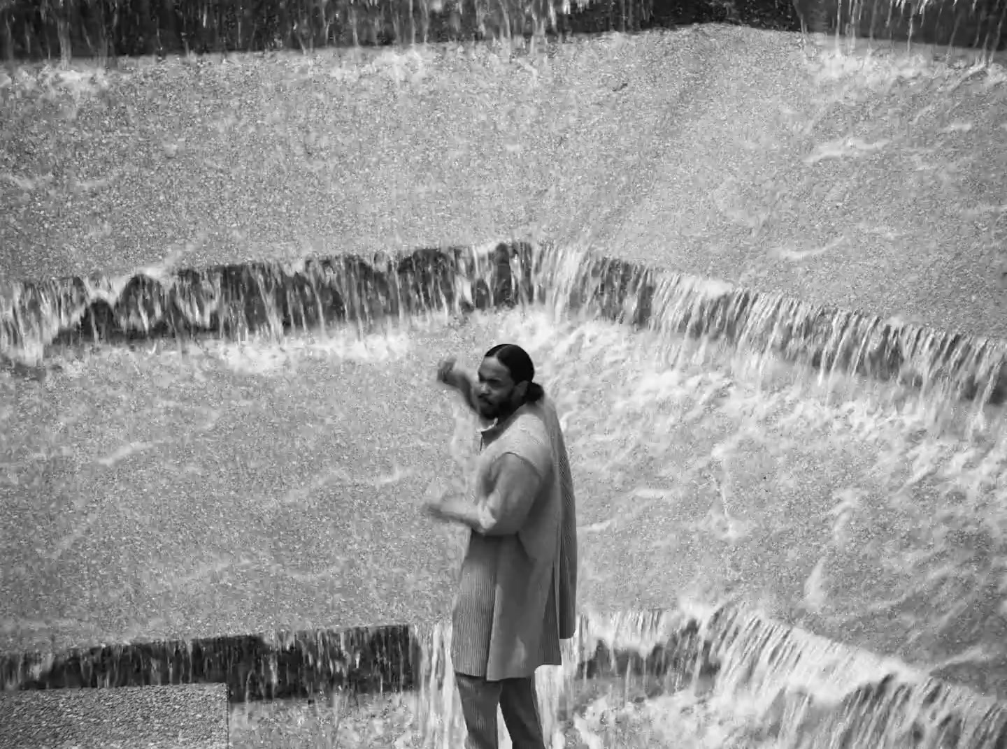 a man standing in front of a waterfall