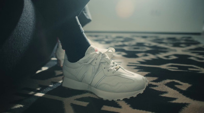 a close up of a person's foot wearing white sneakers