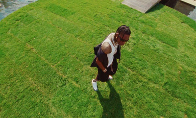 a woman walking across a lush green field