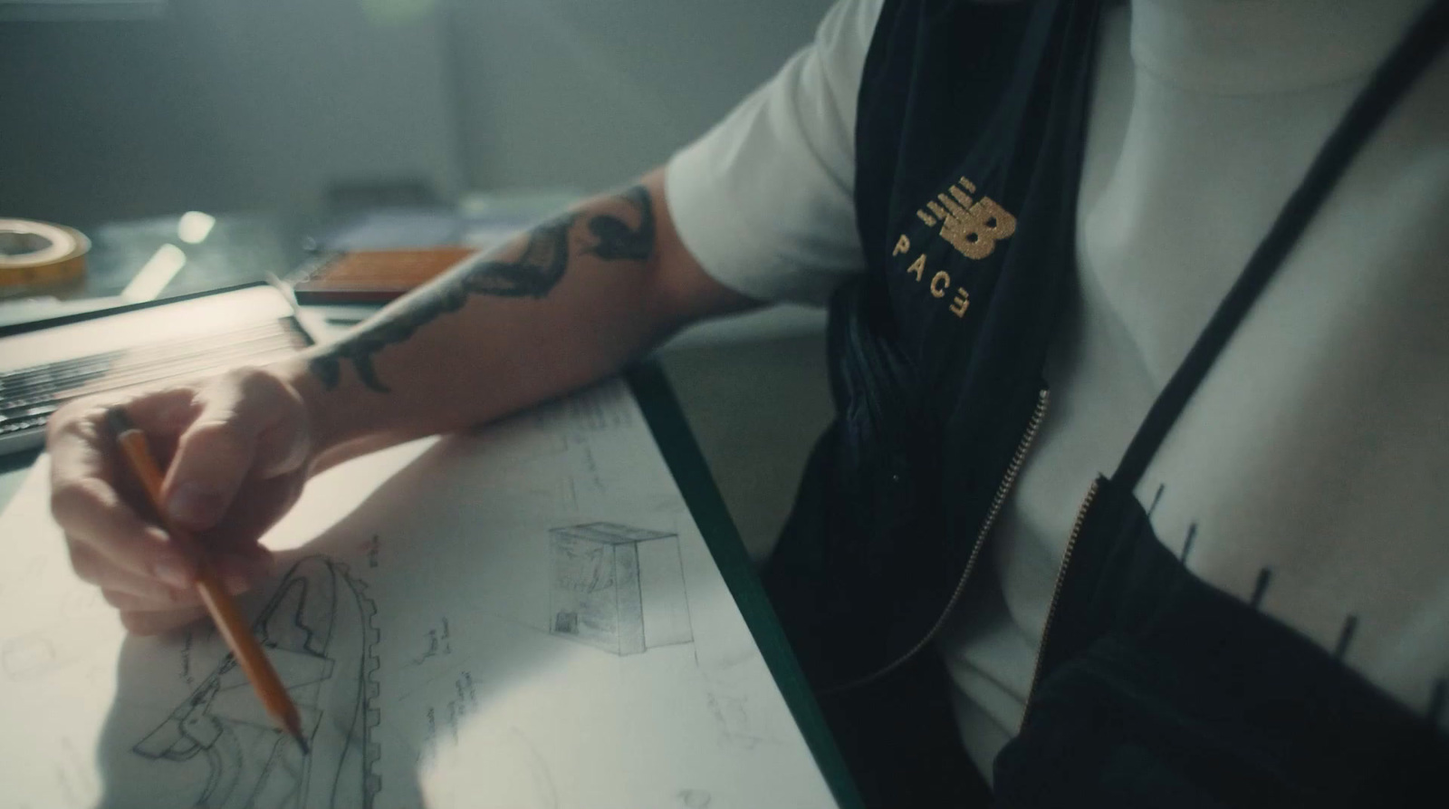 a man with a tattoo on his arm writing on a piece of paper