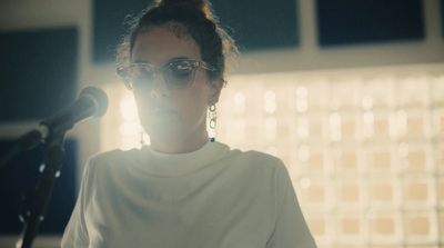 a woman with glasses standing in front of a microphone