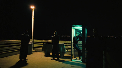 a group of people standing on a pier at night