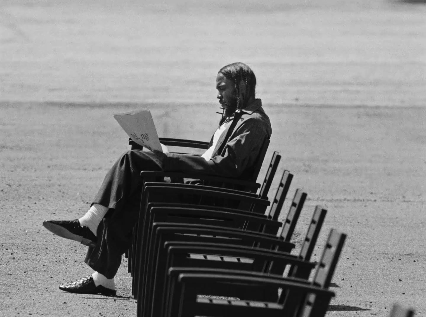 a man sitting in a chair reading a paper