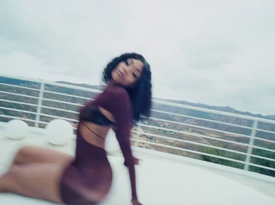 a woman in a purple dress posing on a balcony