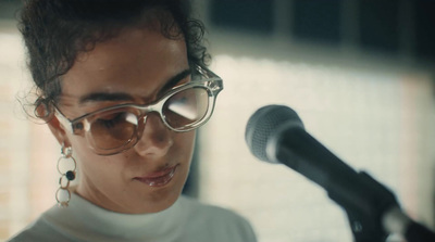 a woman wearing glasses while holding a microphone