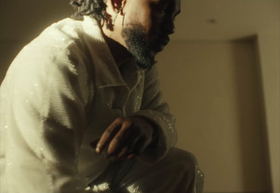 a man with curly hair and a beard sitting down