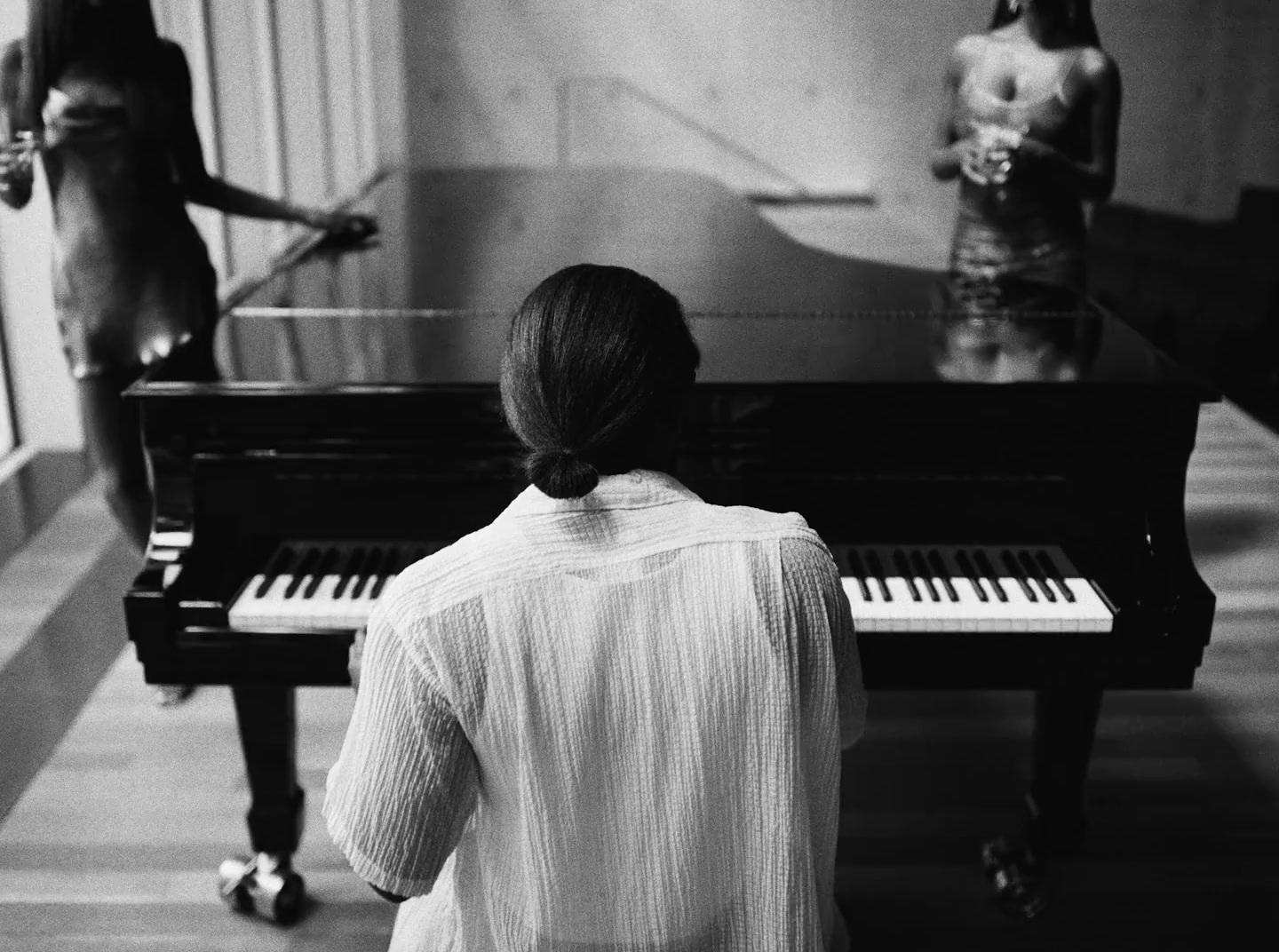 a woman sitting in front of a piano