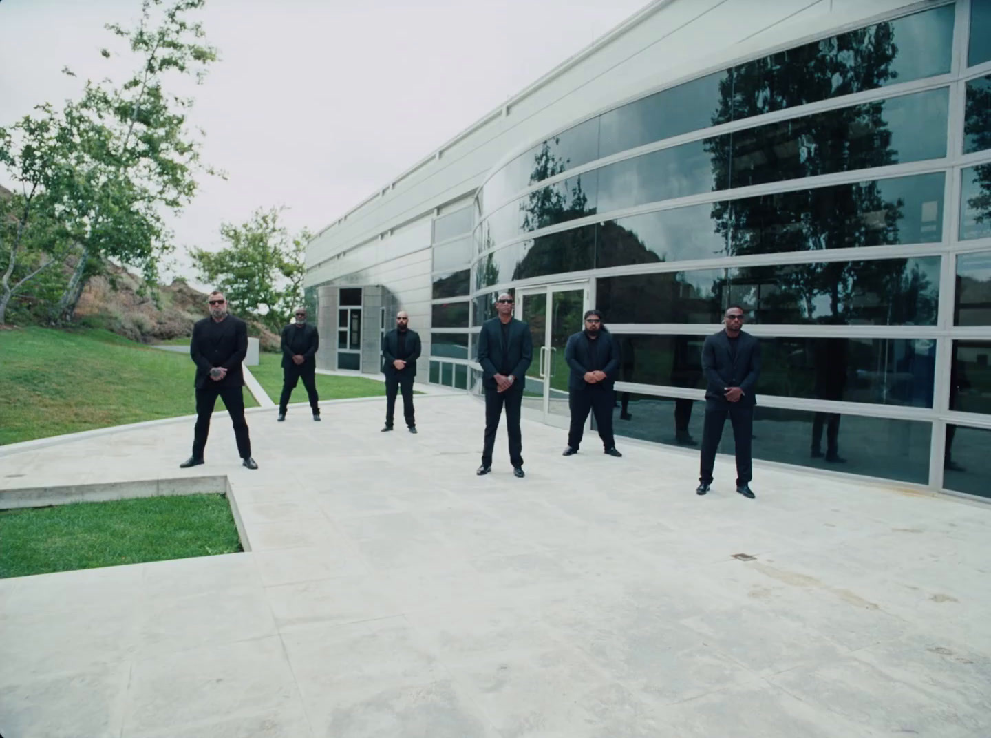 a group of men in suits standing in front of a building