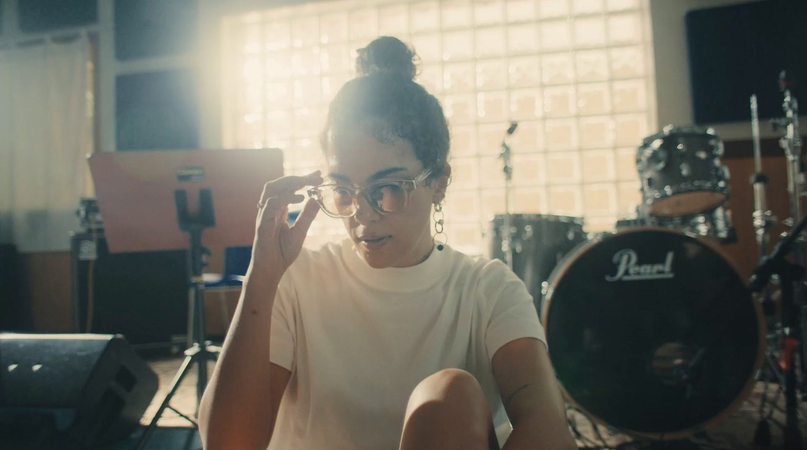 a woman sitting in front of a drum set