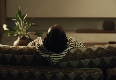 a person laying on a couch with a plant in the background