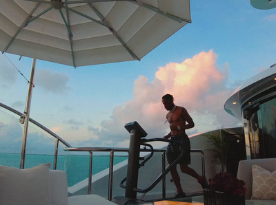 a man standing on top of a boat next to an umbrella