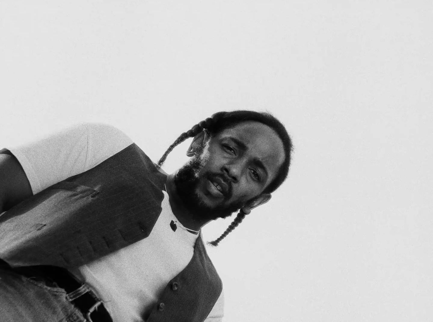 a black and white photo of a man with dreadlocks