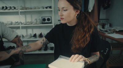 a woman sitting at a table with a notebook in front of her