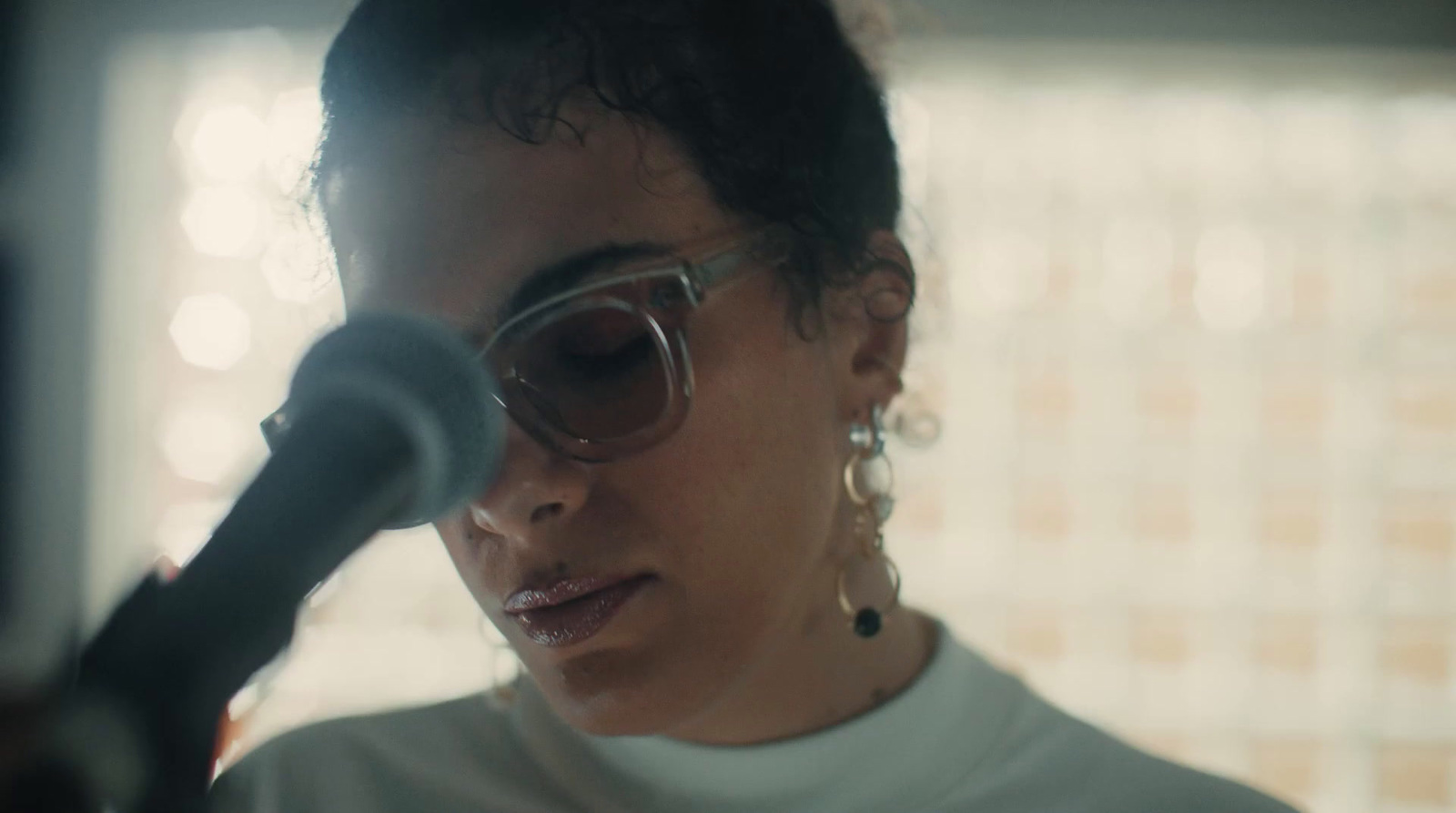 a woman wearing sunglasses and holding a microphone