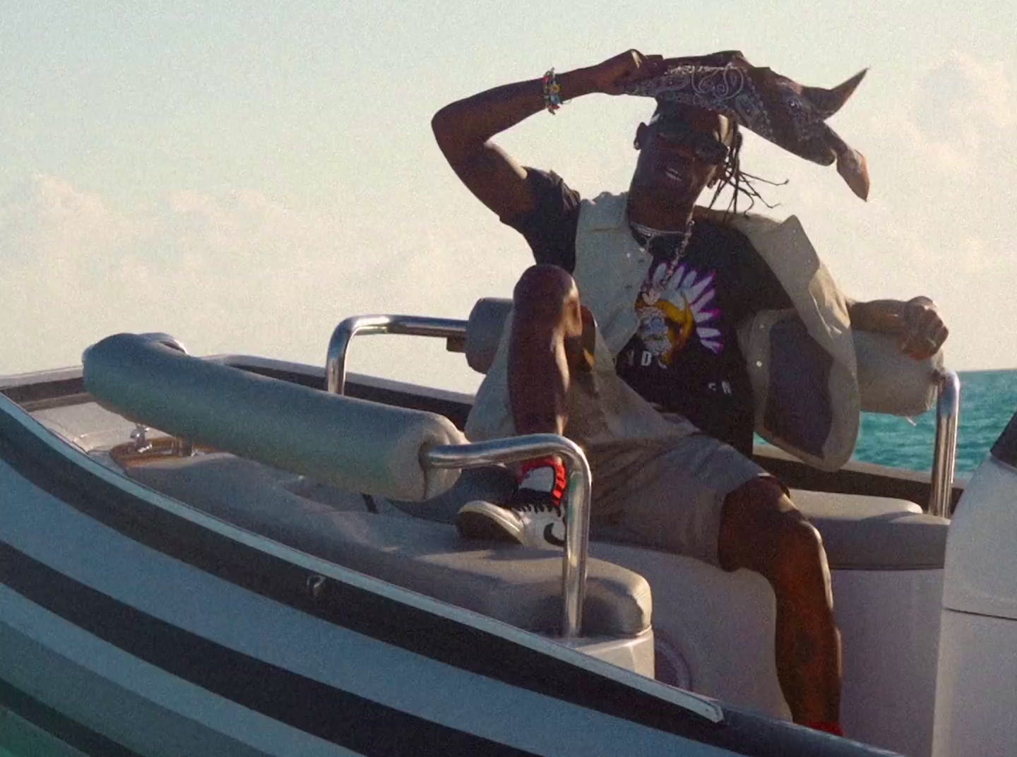 a man sitting in a boat with a fish on his head