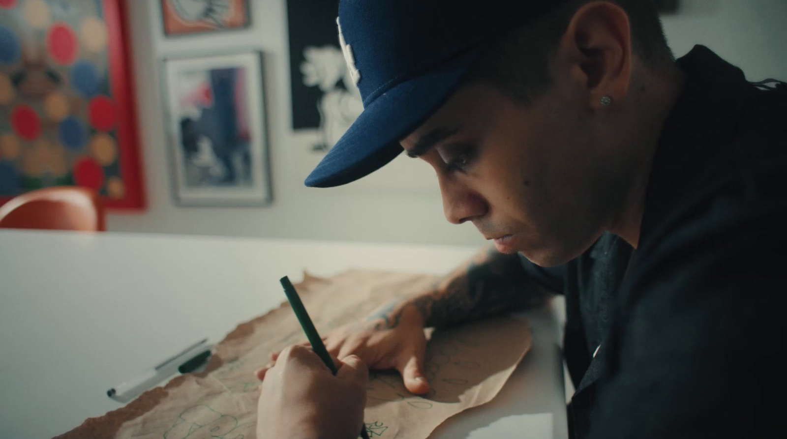 a man sitting at a table writing on a piece of paper