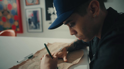 a man sitting at a table writing on a piece of paper