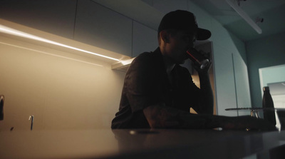 a man sitting at a counter drinking from a bottle