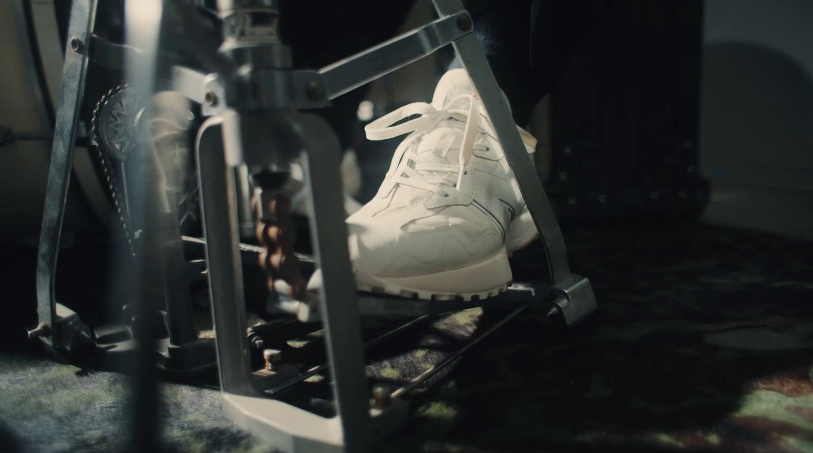 a pair of white shoes sitting on a rack