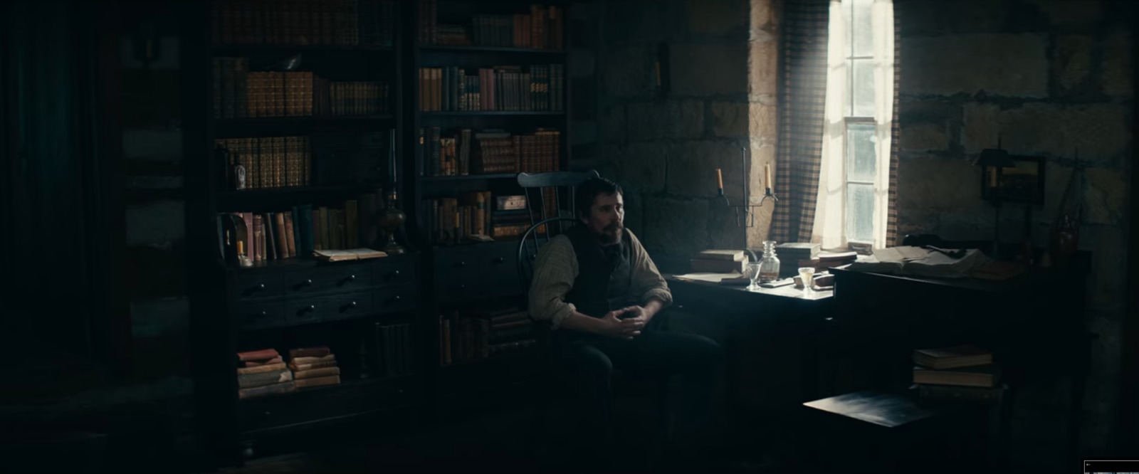 a man sitting in a chair in front of a window