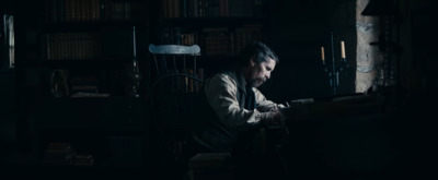 a man sitting in a chair in a dark room