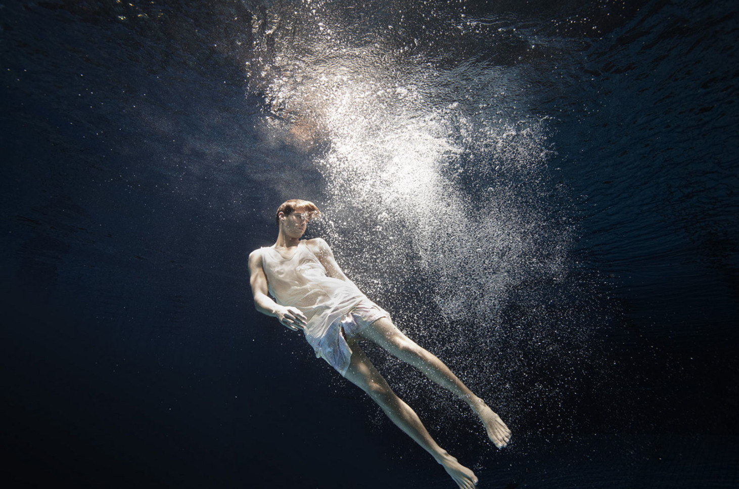 a man floating in the water with his shirt off