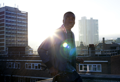 a man standing on top of a roof holding a skateboard