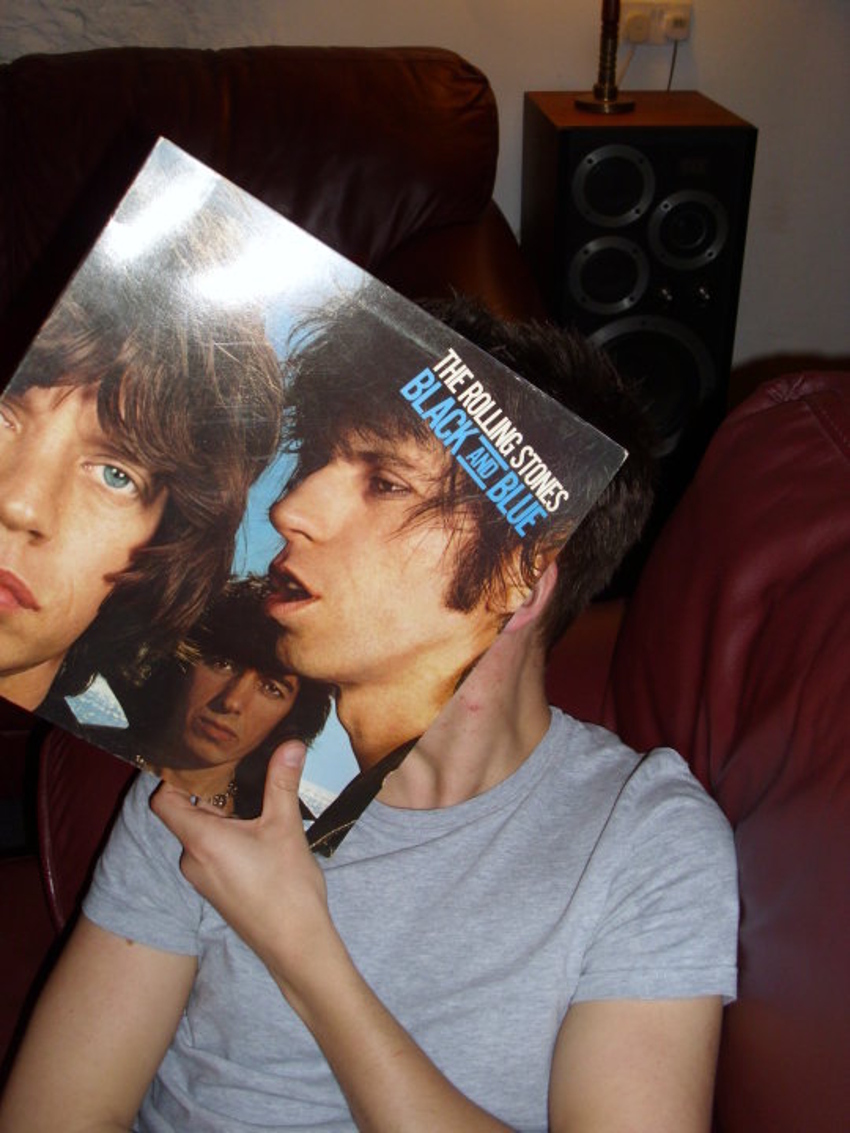 a man holding up a record with the cover of the album