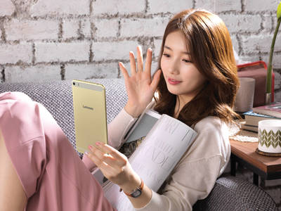 a woman sitting on a couch holding a tablet