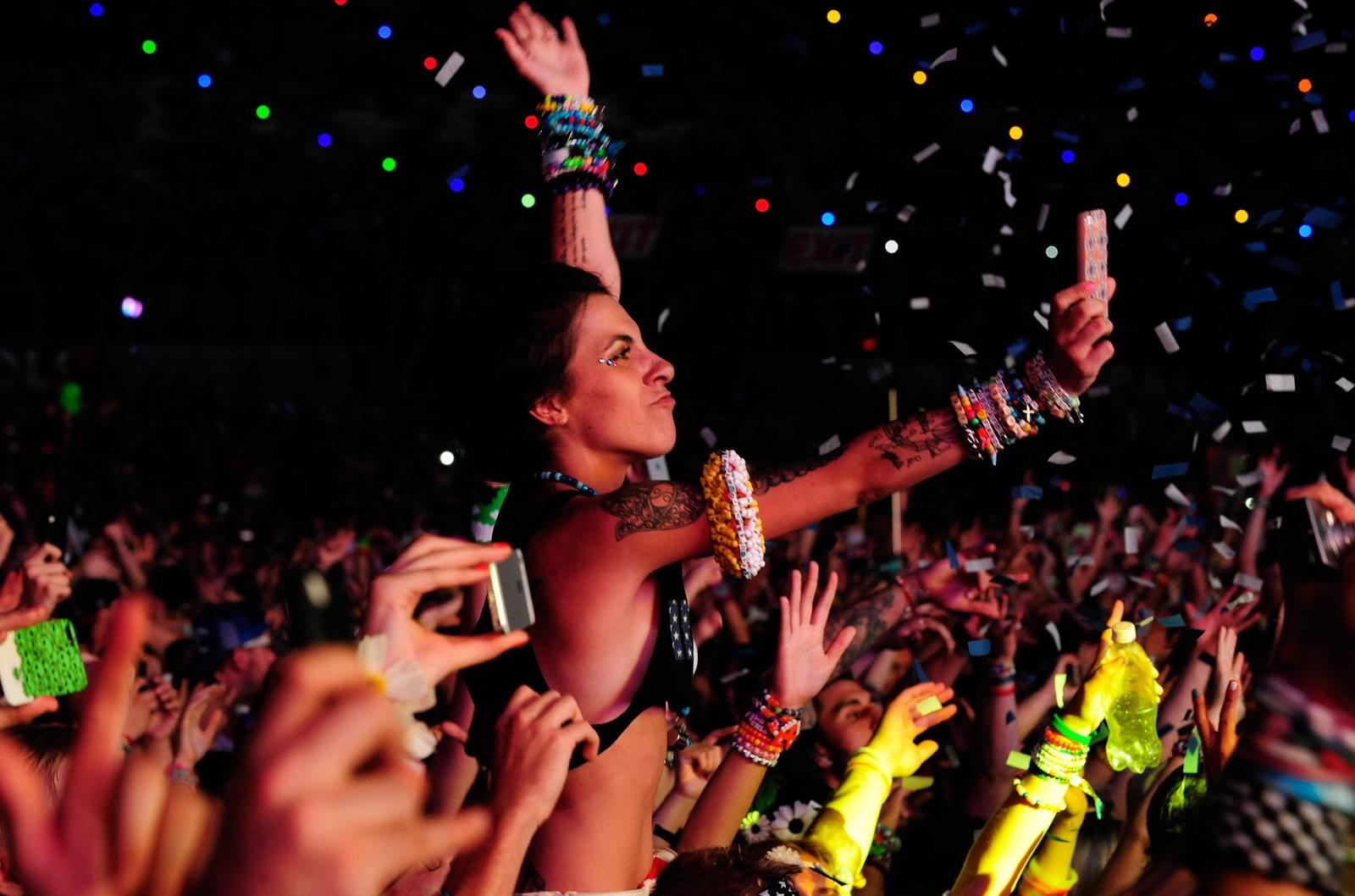 a crowd of people at a concert with confetti thrown in the air