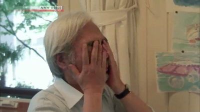 an older man covering his face with his hands