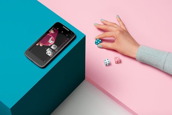 a woman's hand holding a dice next to a phone