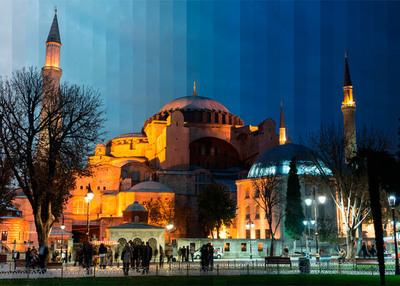 a large building lit up at night with people walking around