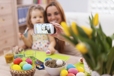 a woman taking a picture of a child with a cell phone