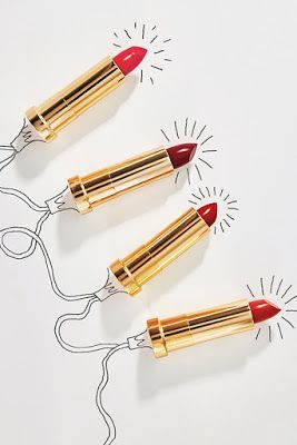 three red lipsticks on a white sheet of paper