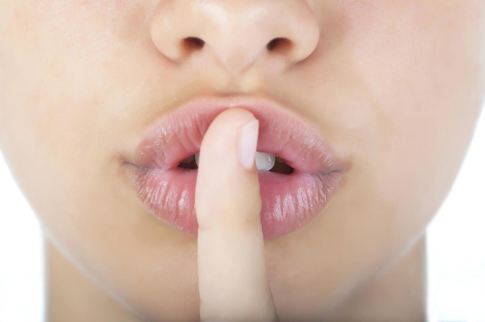 a woman making a hush with her finger