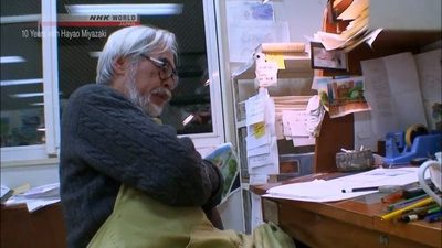 an old man reading a book in an office