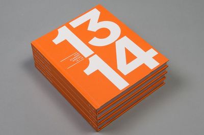 a stack of orange books sitting on top of a table