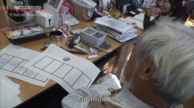 a man sitting at a desk with papers and pens