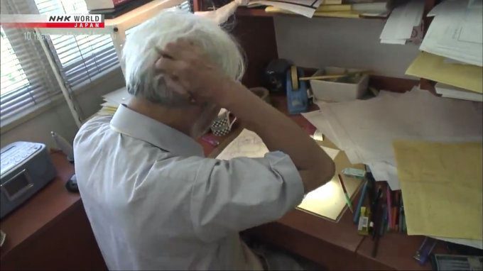 a man in a white shirt is talking on a cell phone