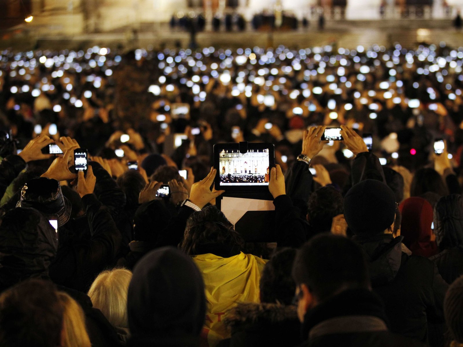 a crowd of people holding up their cell phones