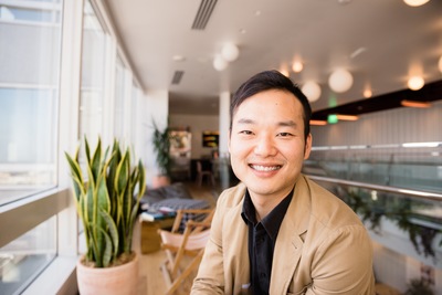 a man sitting in front of a potted plant