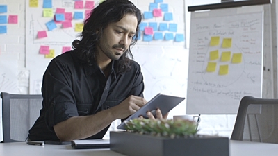 a man sitting at a table with a tablet