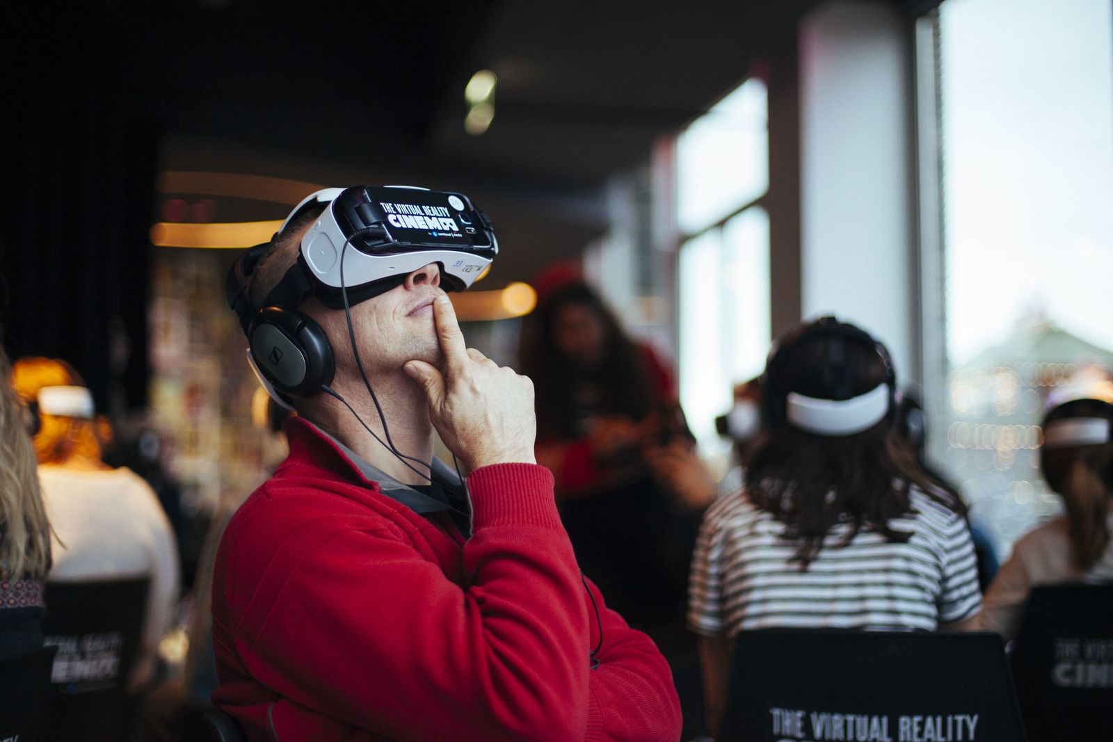 a man wearing a virtual reality headset in front of a group of people