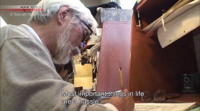 a man with a beard is working on a piece of wood