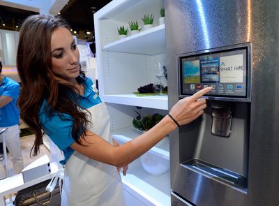 a woman in an apron is looking at a refrigerator