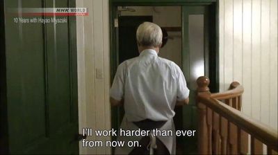 a man walking down a hallway next to a green door