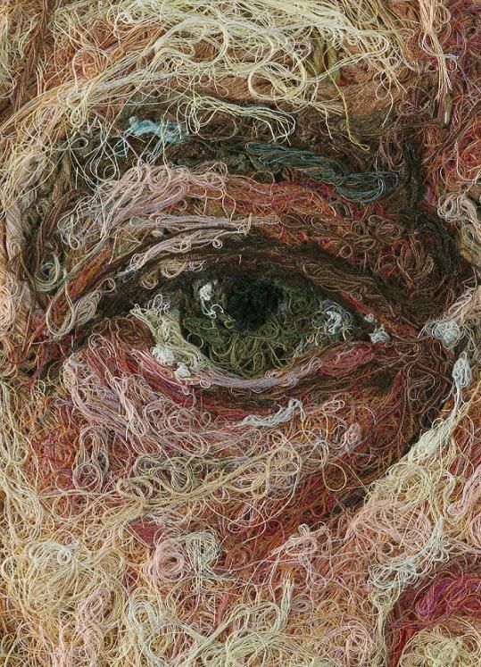 a close up of a man's face with a lot of yarn on it