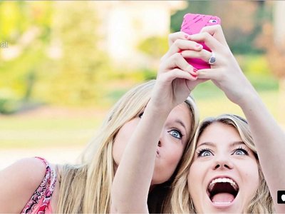 two young women taking a picture with a cell phone