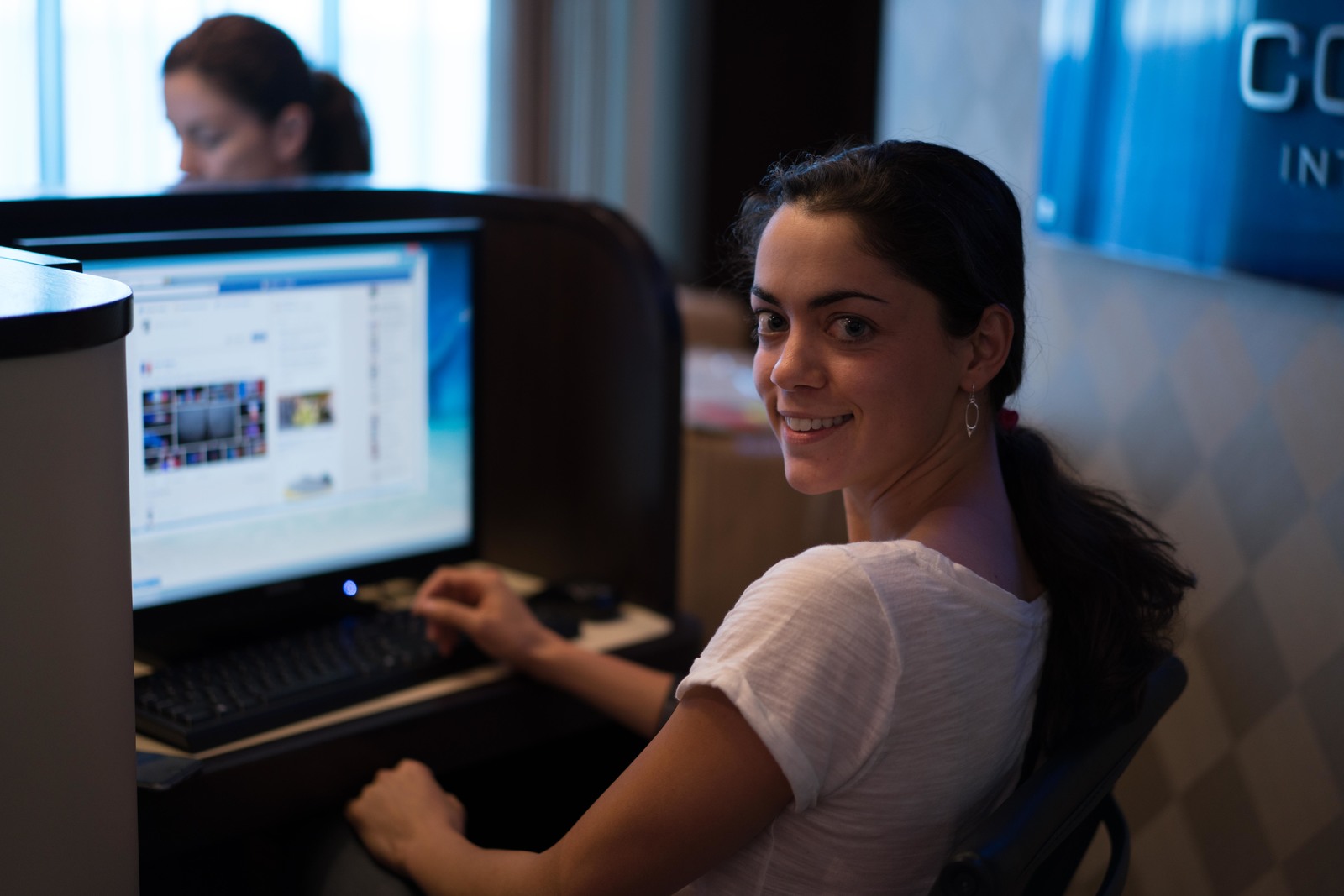 a woman sitting in front of a computer monitor